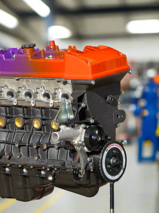 Engine block with orange and black components on a dark background