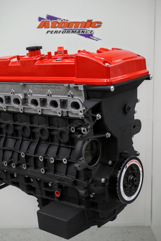 complete engine block with orange rocker cover with white background with logo