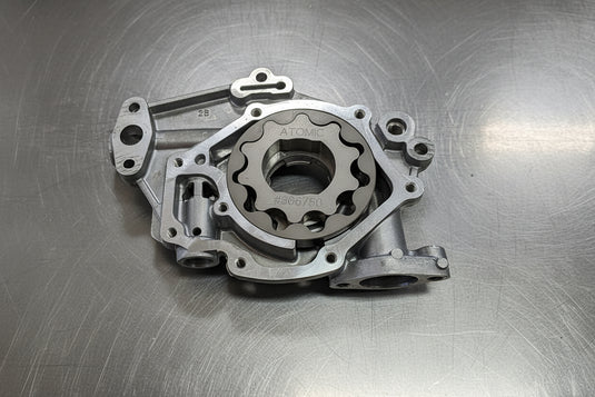 steel oil pump gears in an aluminium oil pump housing with a steel background