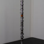 Camshaft on a black surface with a white background