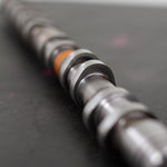 Close-up of a mechanical camshaft on a dark surface
