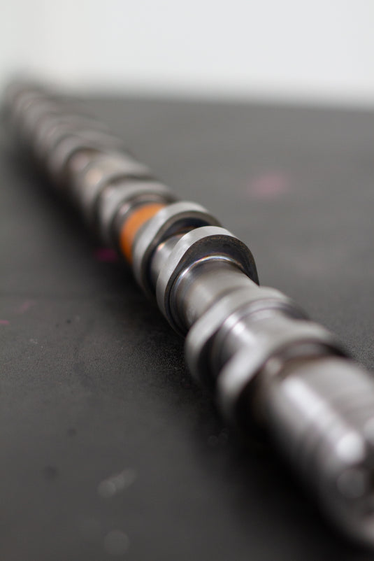 Close-up of a mechanical camshaft on a dark surface