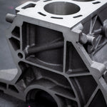 cast engine block on a black bench