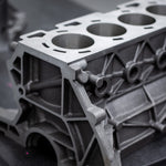 cast engine block on a black bench