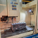 cast engine block being machined