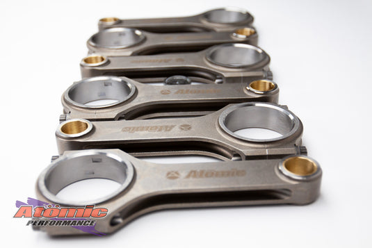 Set of metallic connecting rods with 'Atomic' branding on a white background