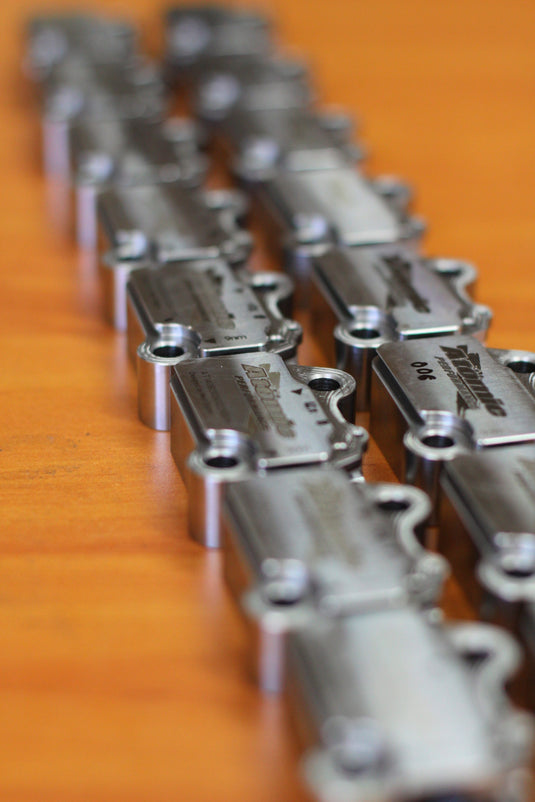 silver engine tensioners lined up on orange surface 