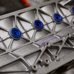 Metal engine block with blue bolts and 'Atomic' branding on a blurred background