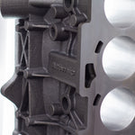 close up of upright cast engine block with white background