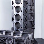 cast engine block on a black surface with a white background