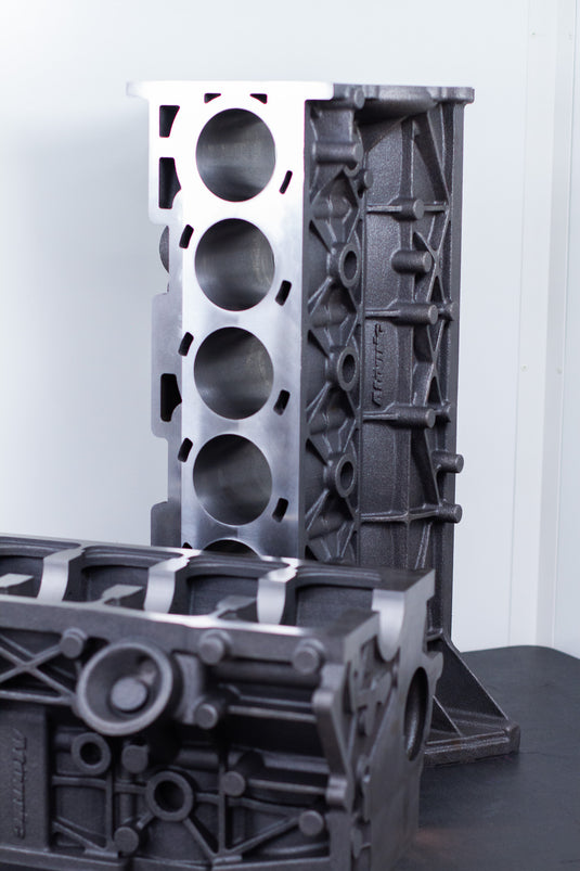 cast engine block on a black surface with a white background