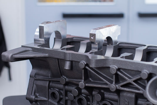 close-up of silver main caps on cast engine block in a workshop setting 