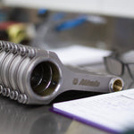 upright engine connecting rods lined up with a workshop setting background