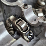 close-up of engine roller rocker and valve spring inside cylinder head 