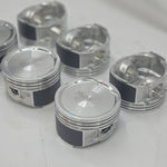 close up of top and underside of  cast engine piston head on white background 