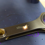 lasering of engine connecting rod with logo with dark background
